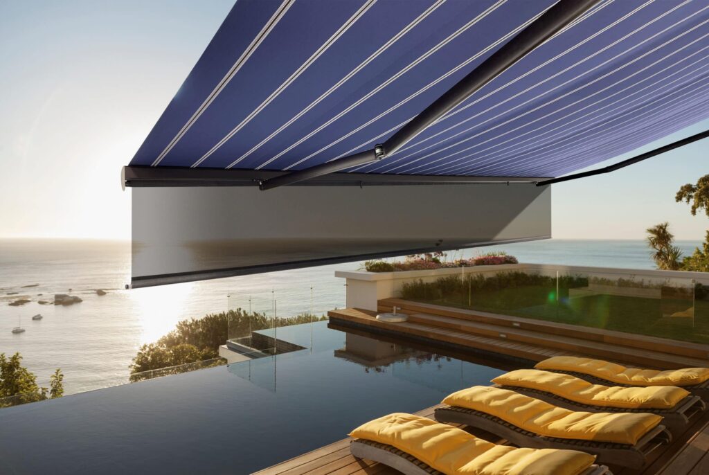 Commercial awning pictured installed over an infinity pool.