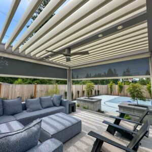 Inside pergola view of motorized solar shade halfway down on custom pergola with opened louvers
