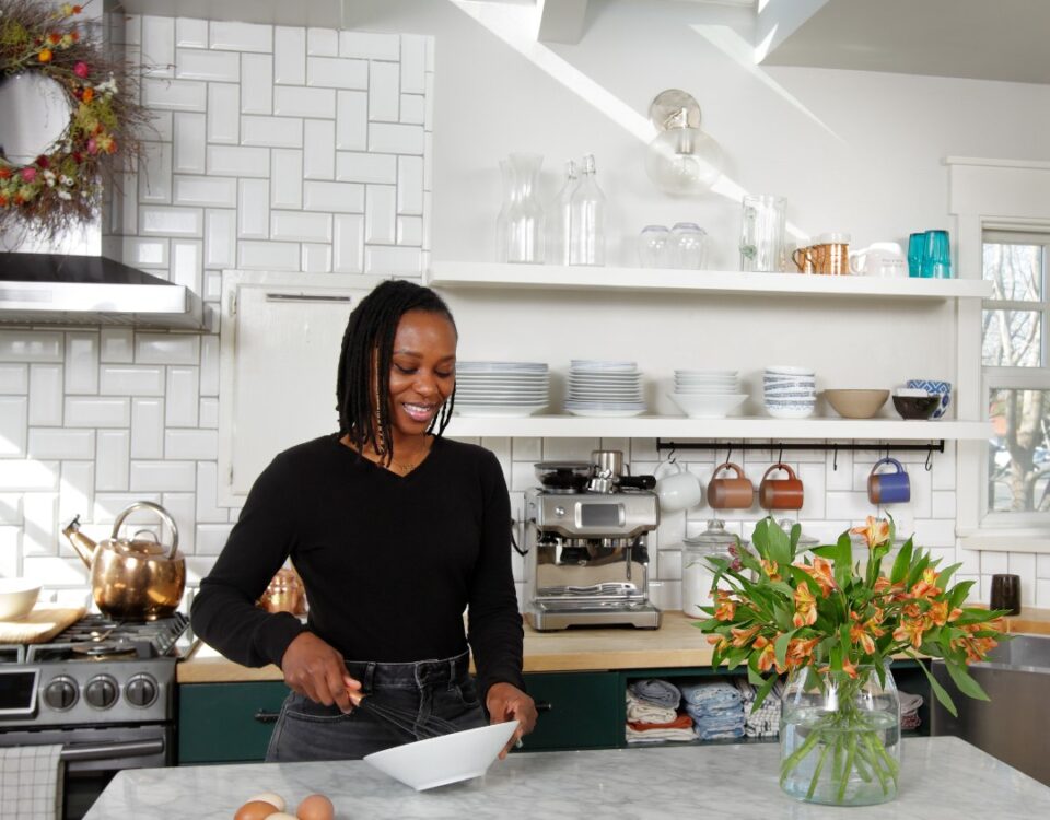 Woman in her kitchen standing beneath skylights that brighten up the space